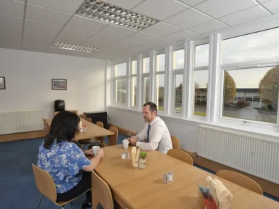 Two people sat at a table in conference room